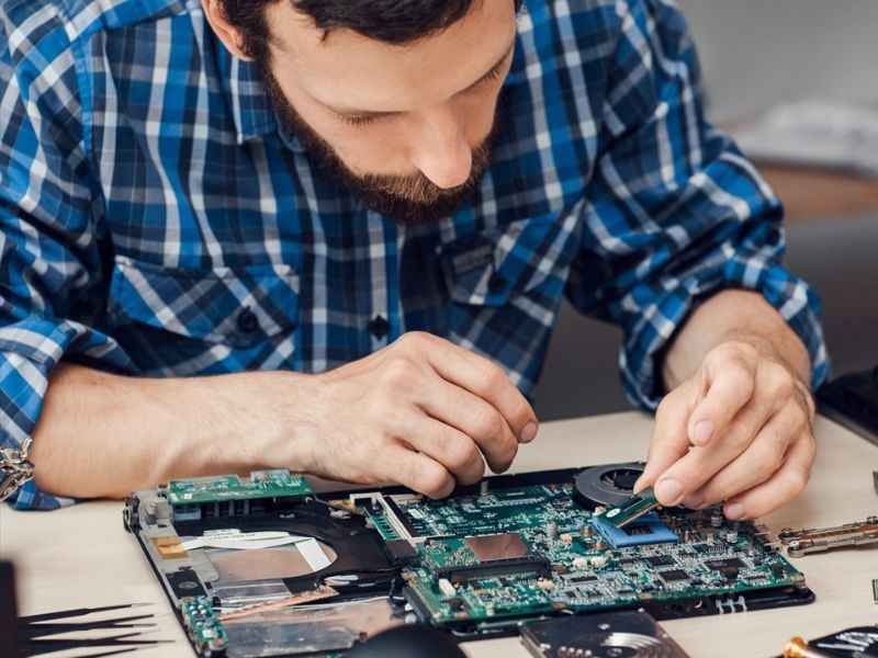 técnico revisando el interior de una laptop