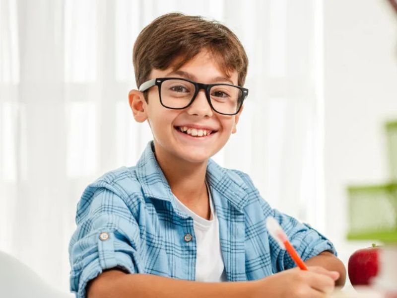 aprovechar las vacaciones: niño feliz estudiando